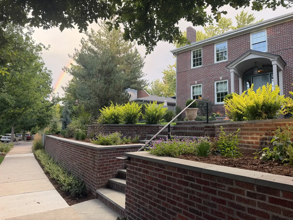 Terraced perennial beds against a brick garden wall