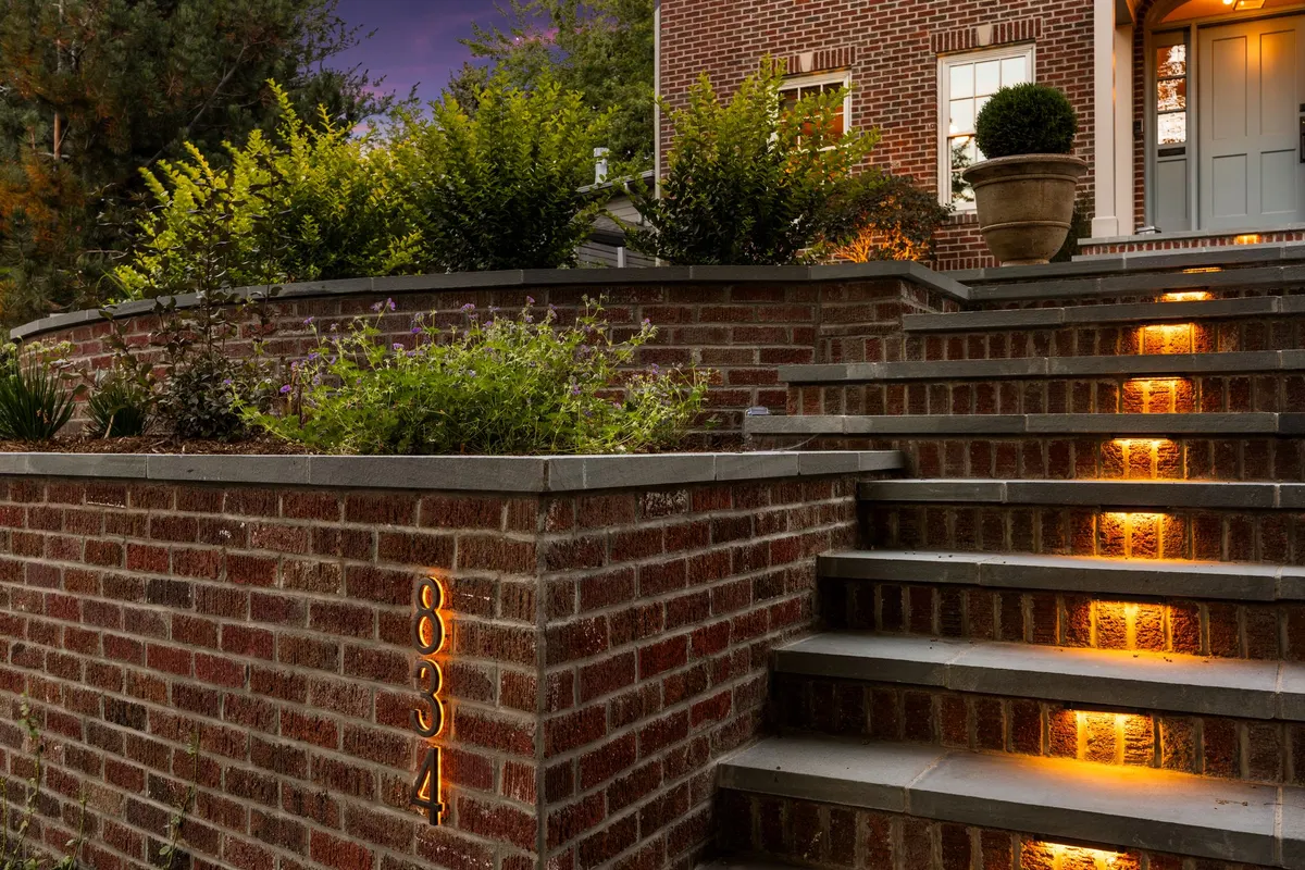 Brick retaining wall with illuminated bluestone steps