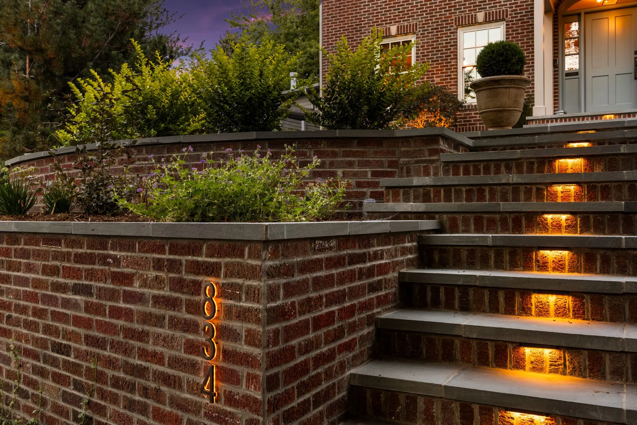 Brick retaining wall with illuminated bluestone stair treads