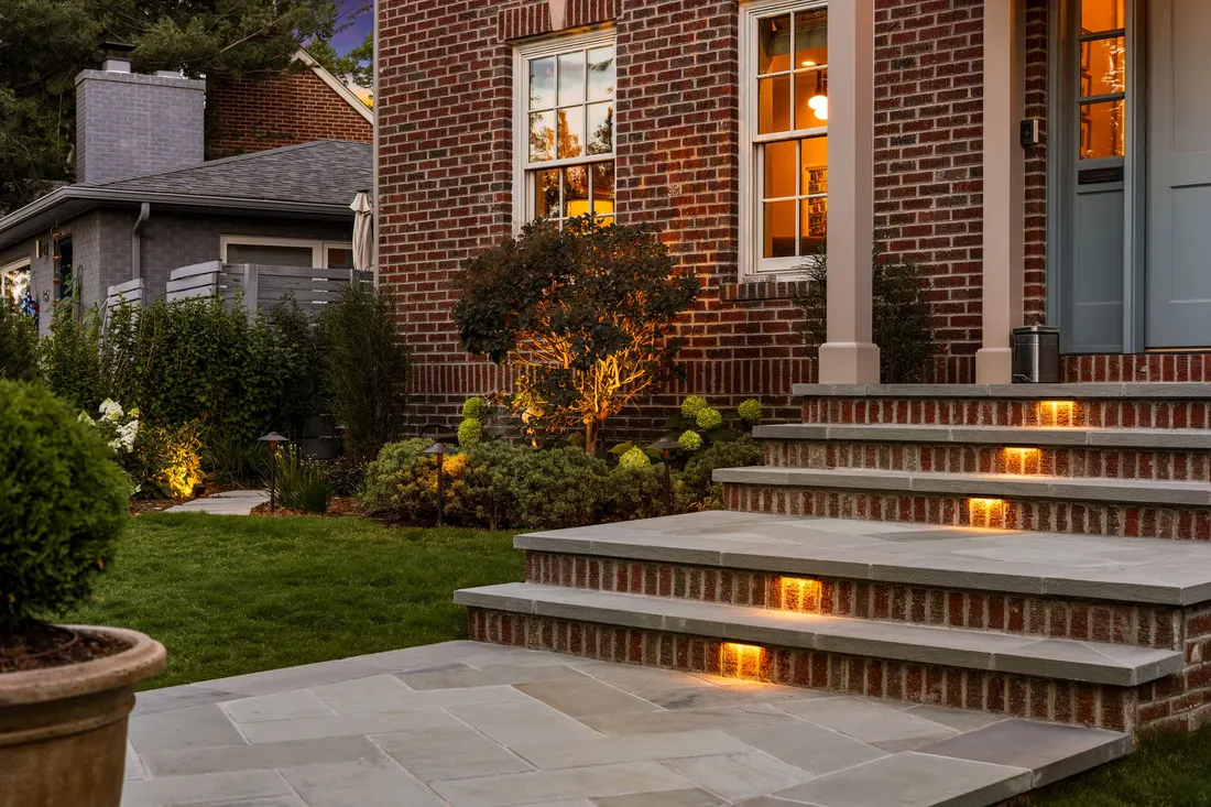 Bluestone steps and planting beside a brick facade
