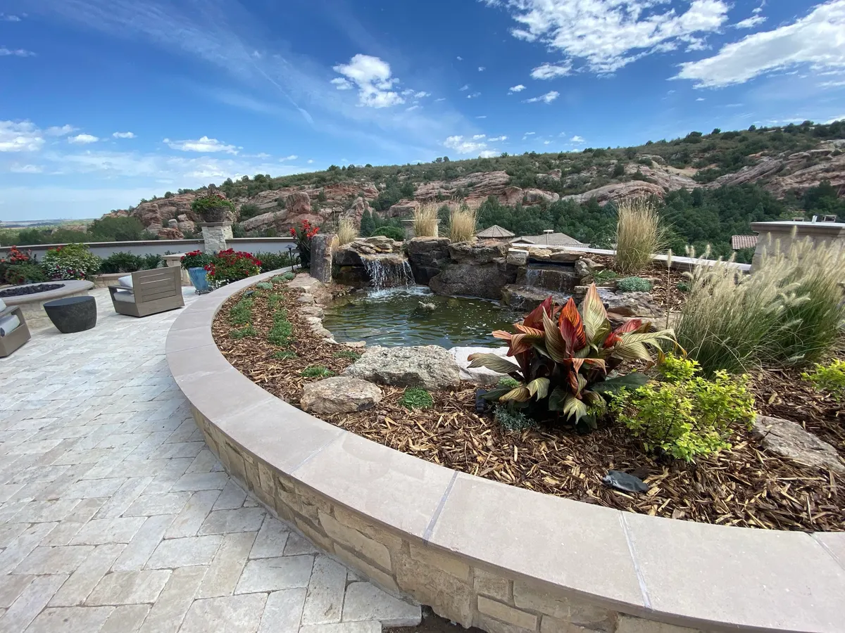 Constructed waterfall and boulder stream running into a planted pool